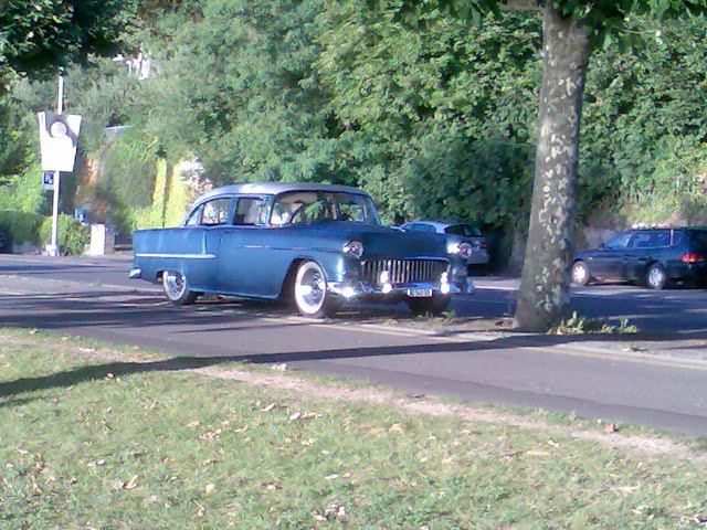 an antique car parked in the middle of the road