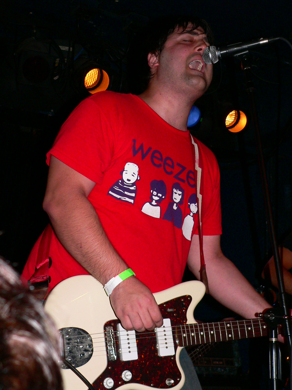 a man with an electric guitar singing into a microphone