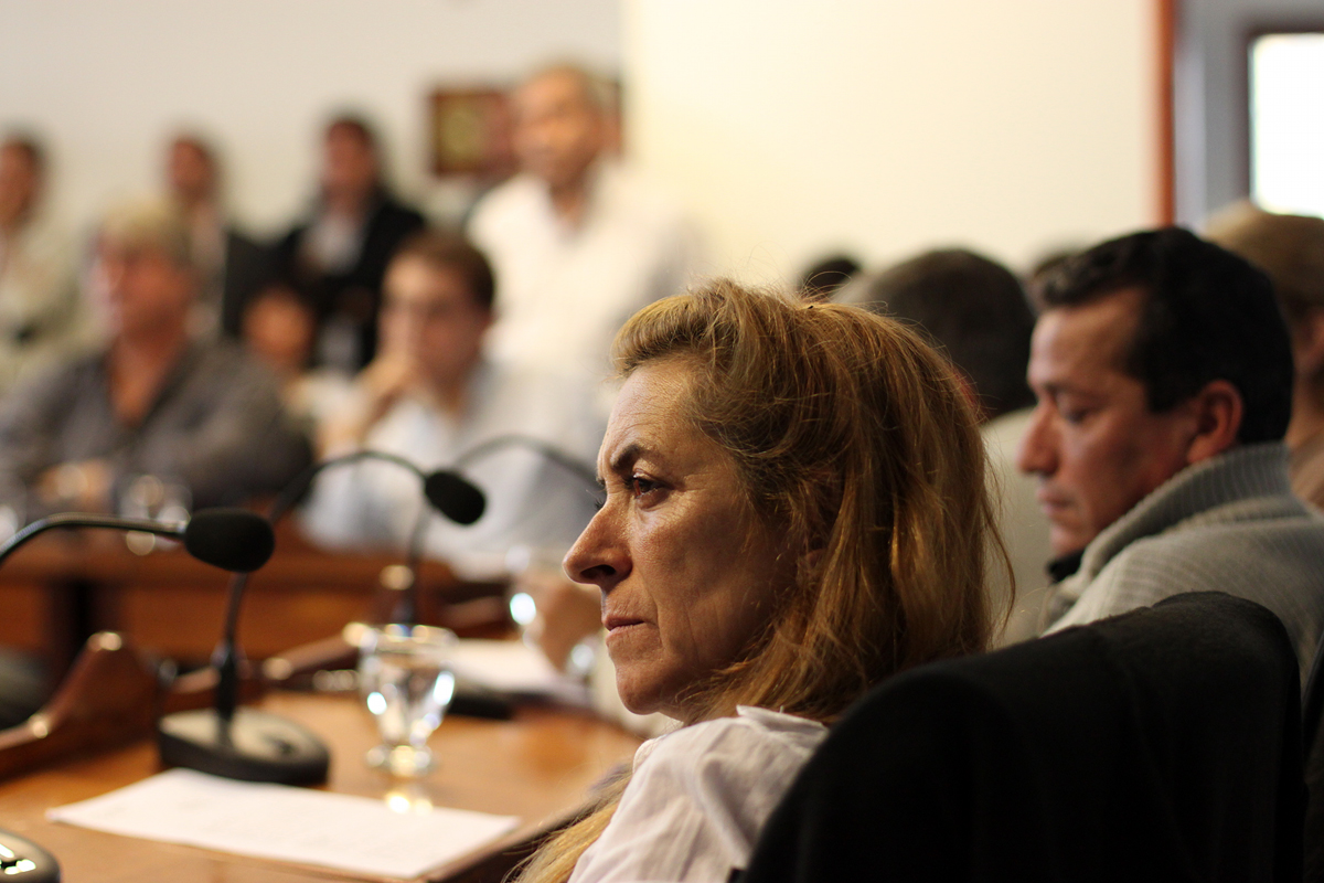 woman looking at man standing beside her speaking in front of the audience