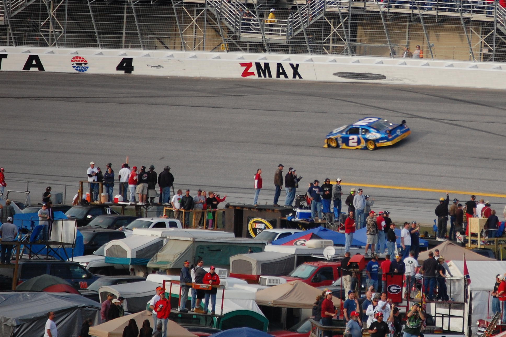 a dirt track with many tents and cars