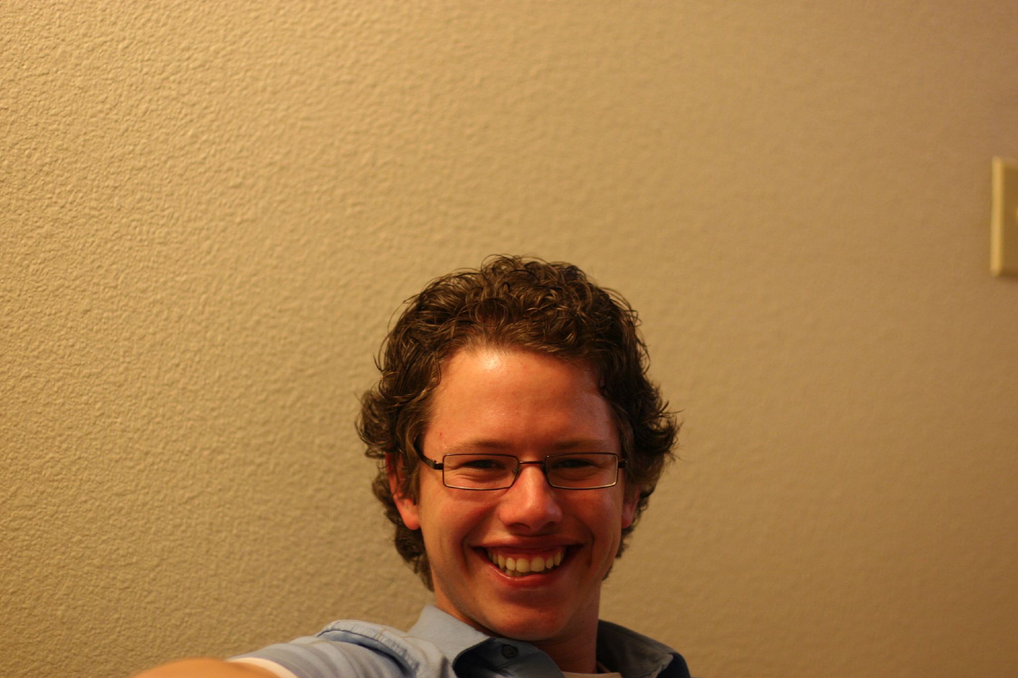 a man in glasses smiling for a picture