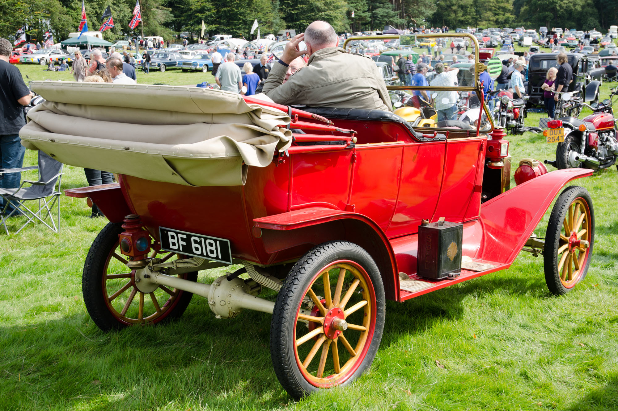 an antique car is on display at an outdoor rally