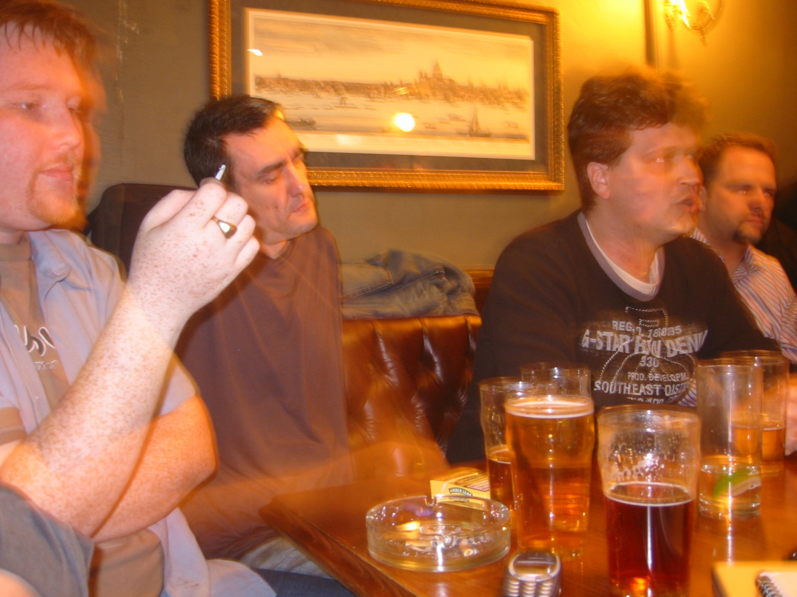 several people sitting at a table in front of beer glasses