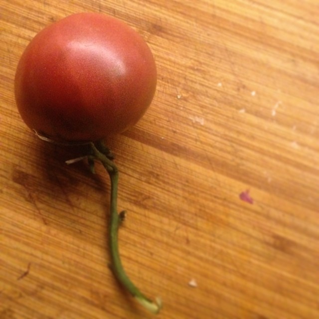 a tomato is sitting on a wooden surface