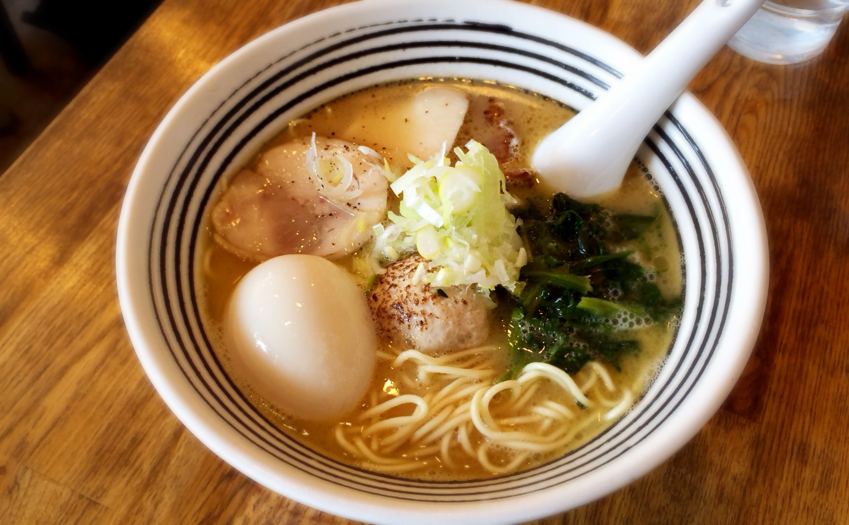 a bowl of ramen with egg, broccoli, and other things