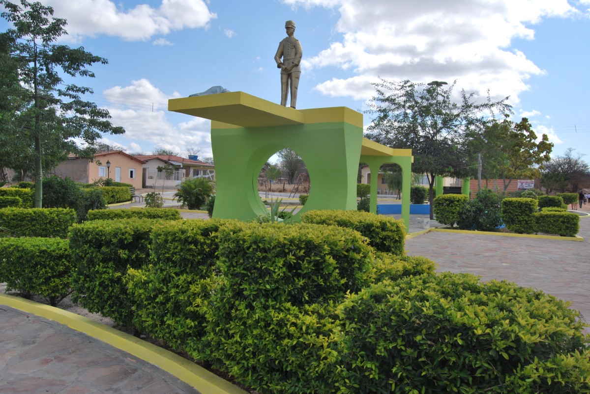 a statue of a man on top of a green box in a garden