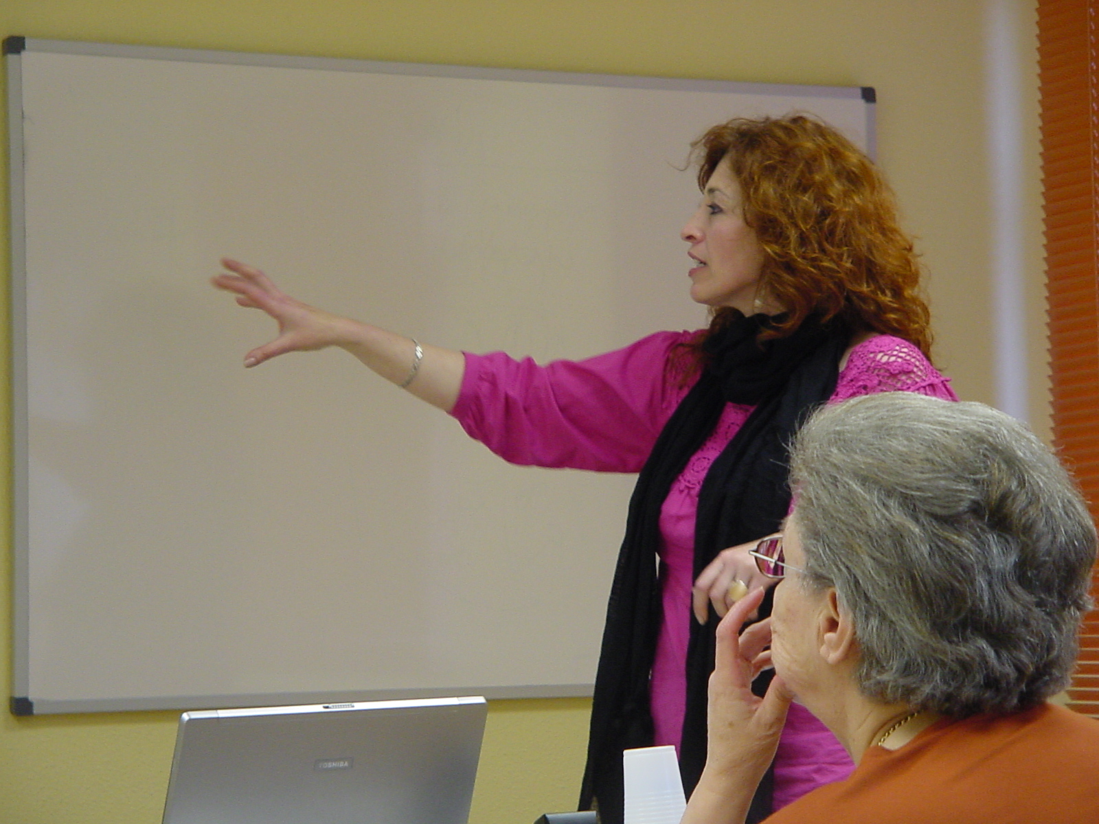 a woman giving a presentation with her hands on a flip chart