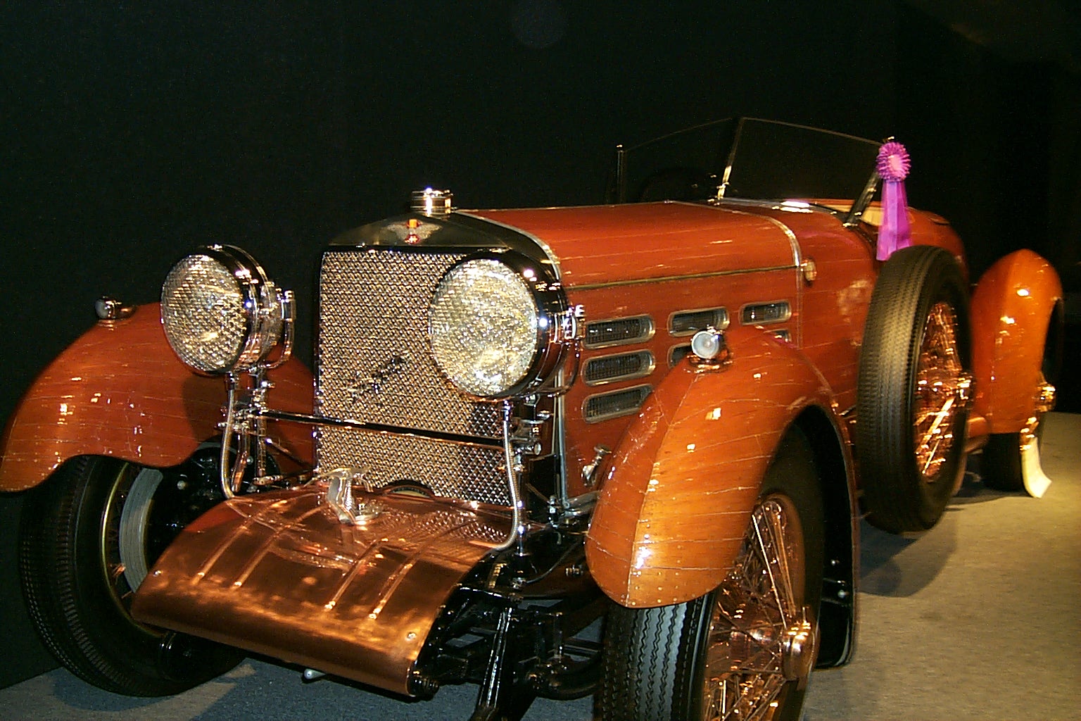 a car with an antique grill on top is on display