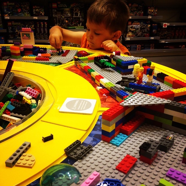 a child playing with lego blocks on a table