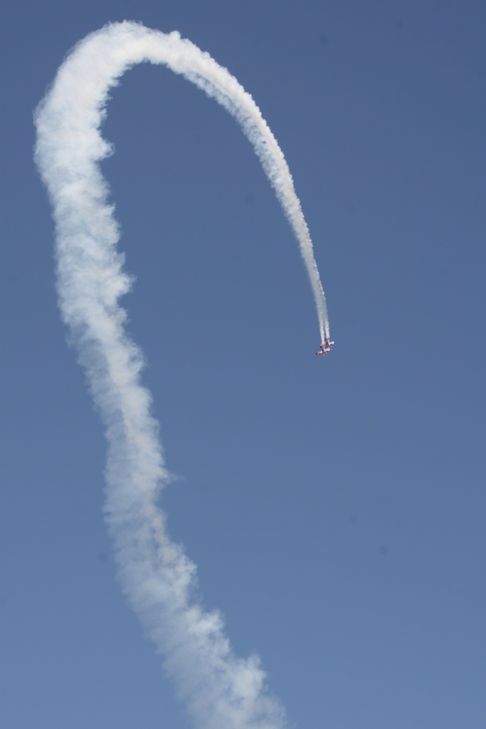 a jet with a trailing stream flying in the sky