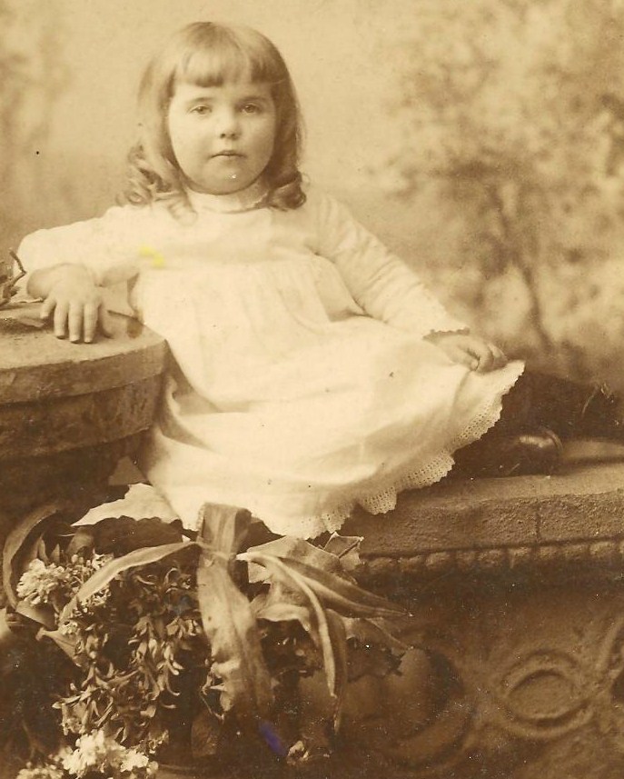 old pograph of little girl seated and posing