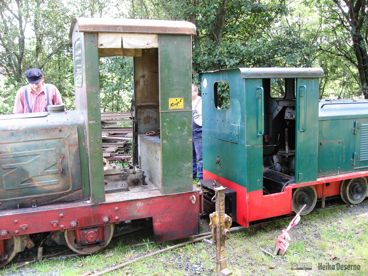 people in a small train sitting on tracks