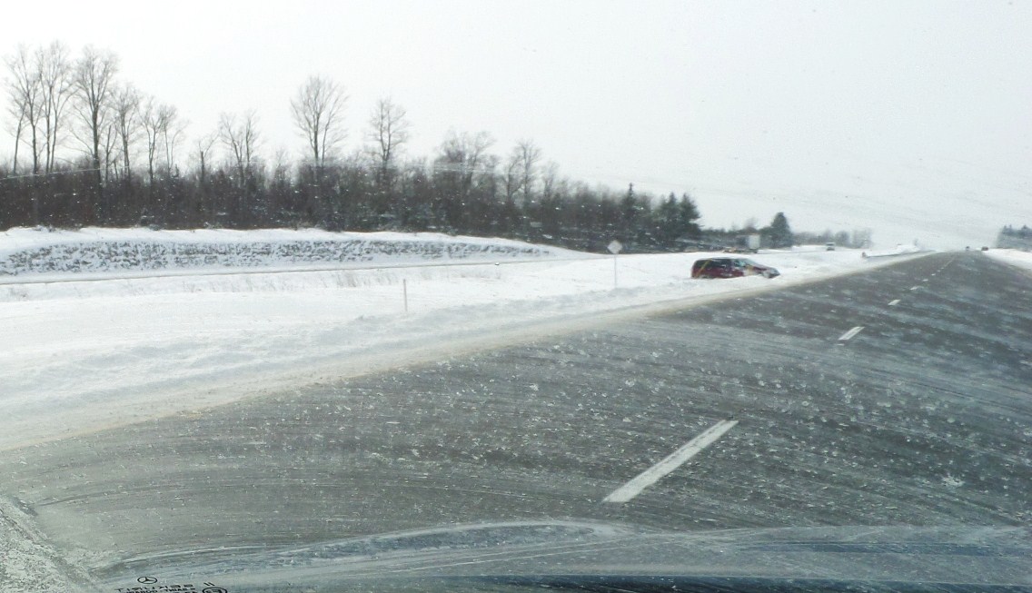 a couple of vehicles are driving down a highway in the winter