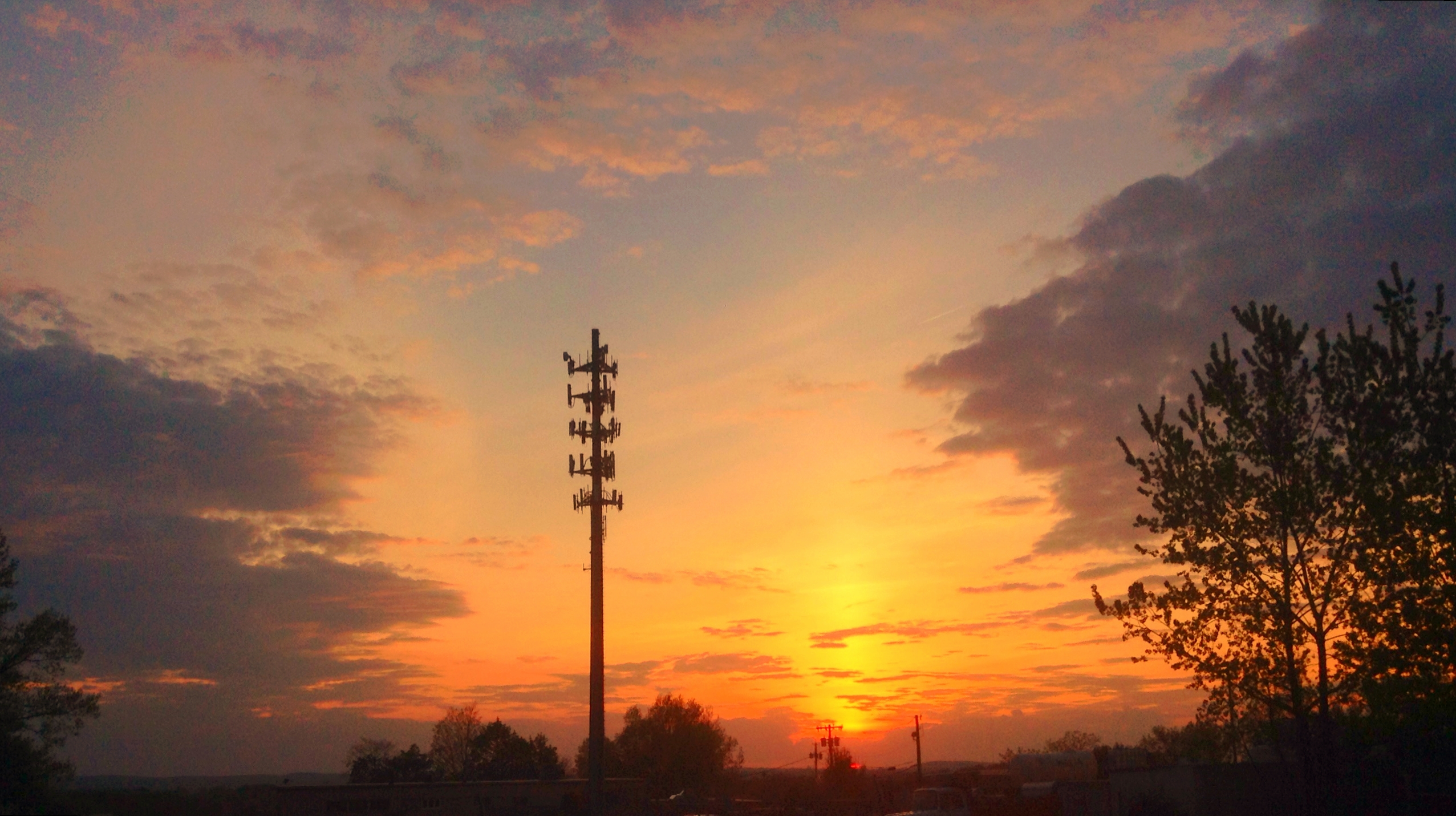 a cell phone tower is silhouetted by the sunset