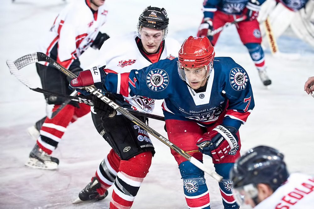 a bunch of people playing in an ice hockey game