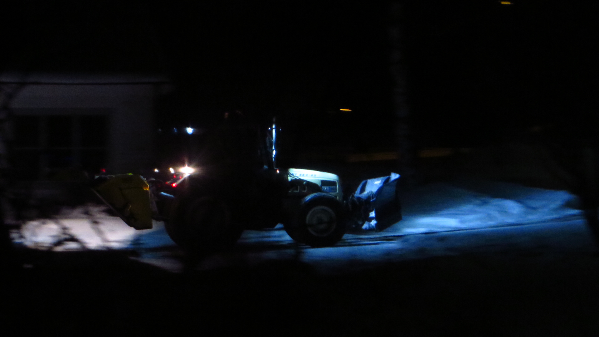 truck with glowing headlights driving on a dark street