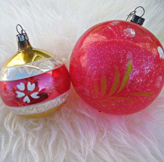 two colorful glass ornaments on white fur