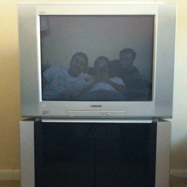 there are three men standing next to the television