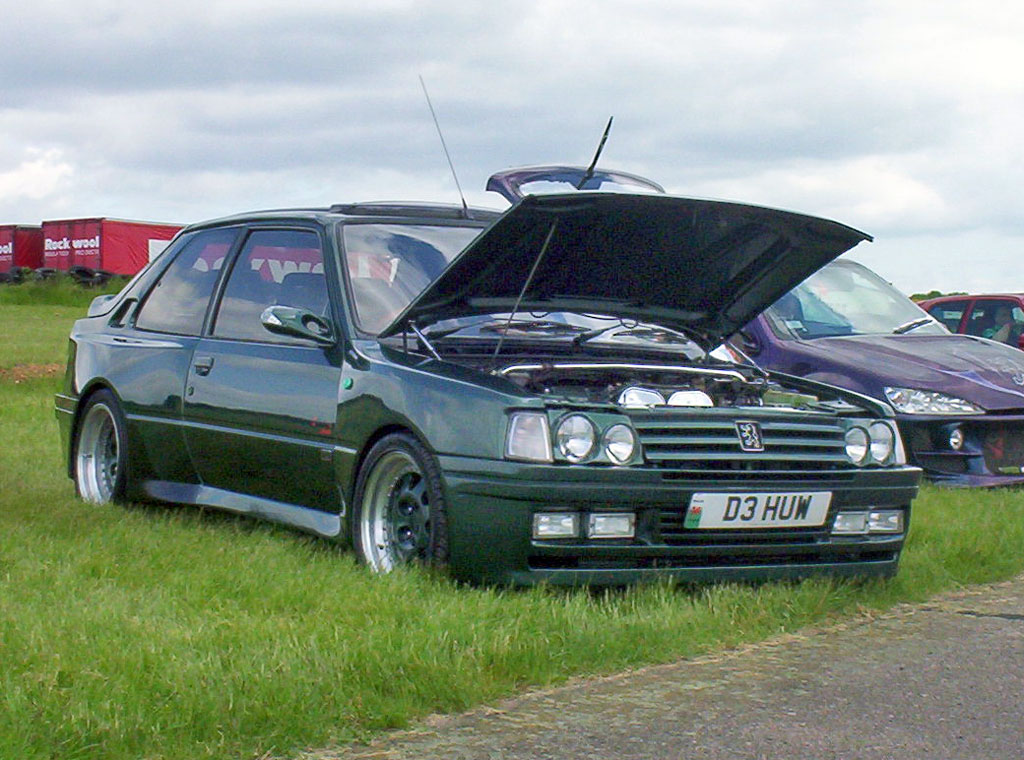 some cars are parked next to one another in a grassy area