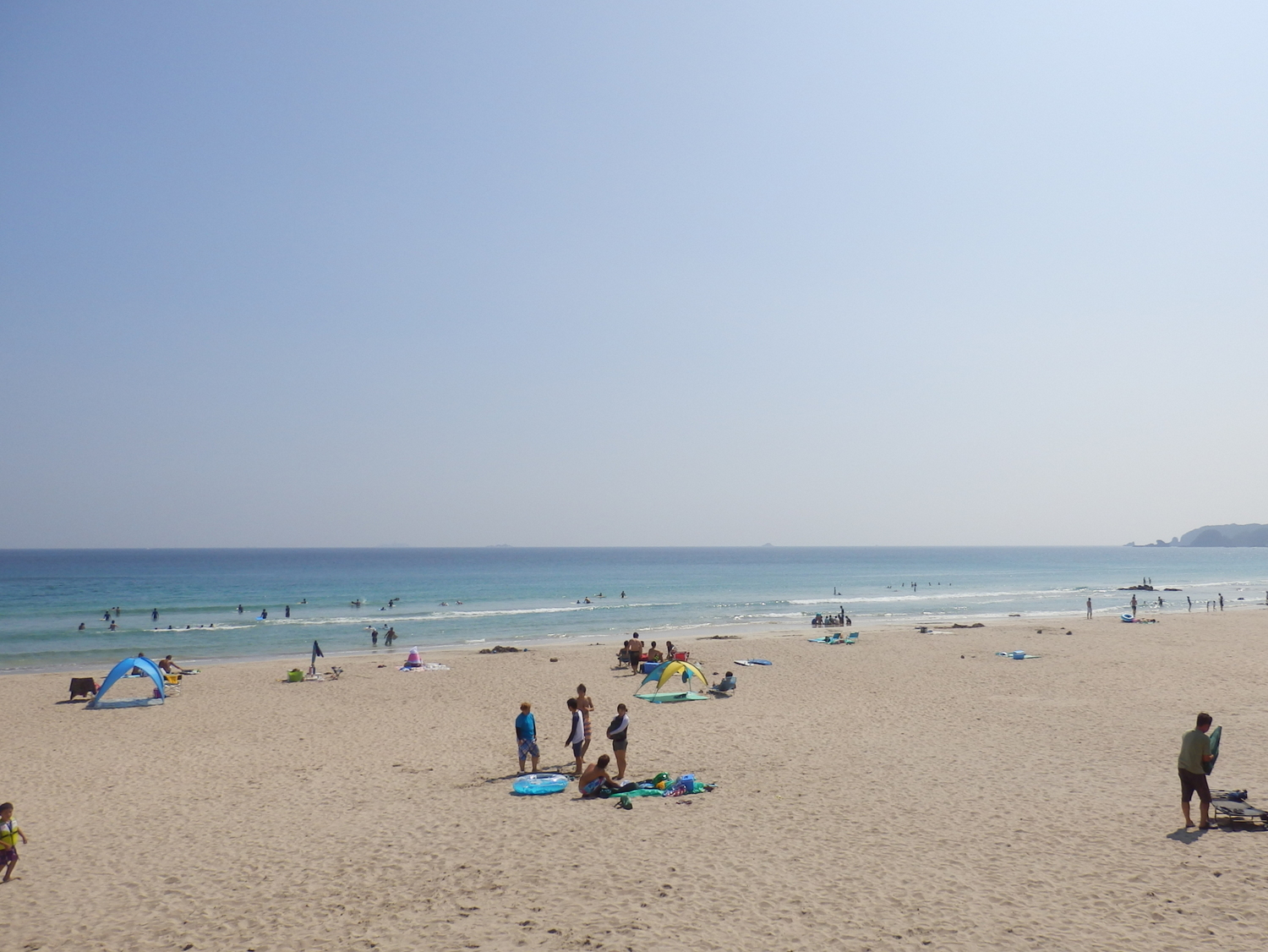 a bunch of people are gathered on the beach