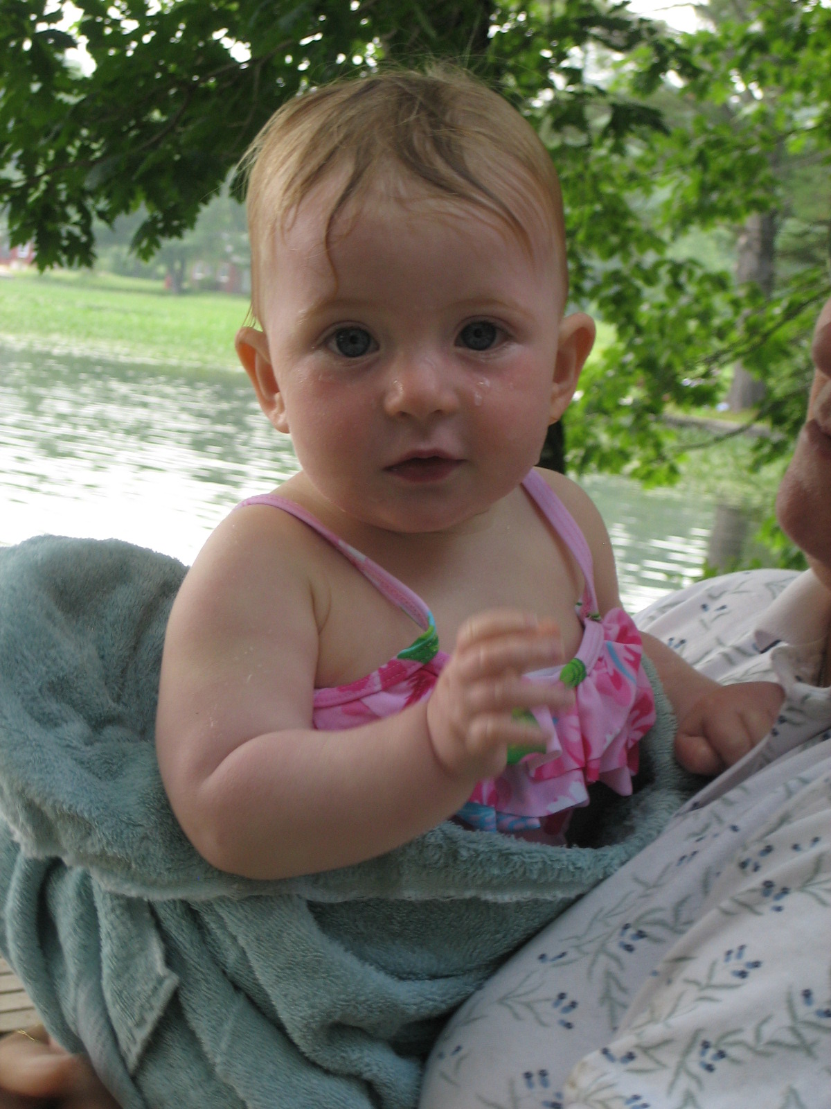 an infant girl holding a towel wrapped around her