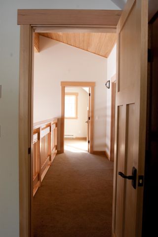 a room with wood paneling and a door leading to another room