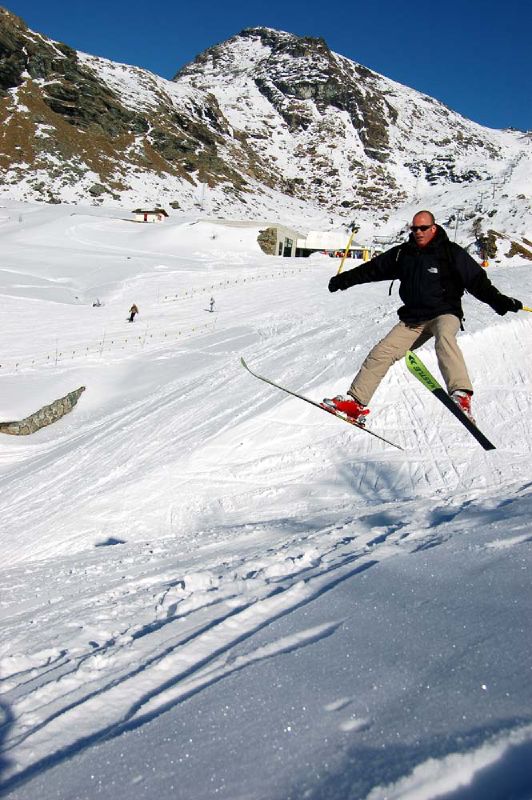 a man in black jacket jumping with skis