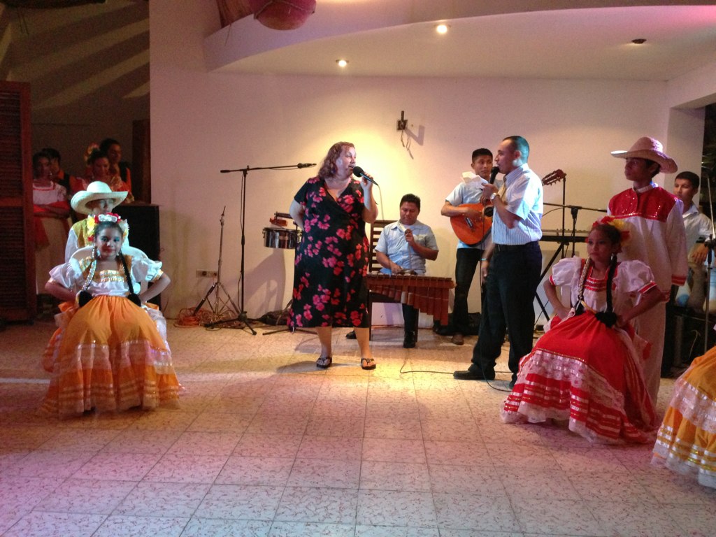 people in mexican costumes stand and sing around a band