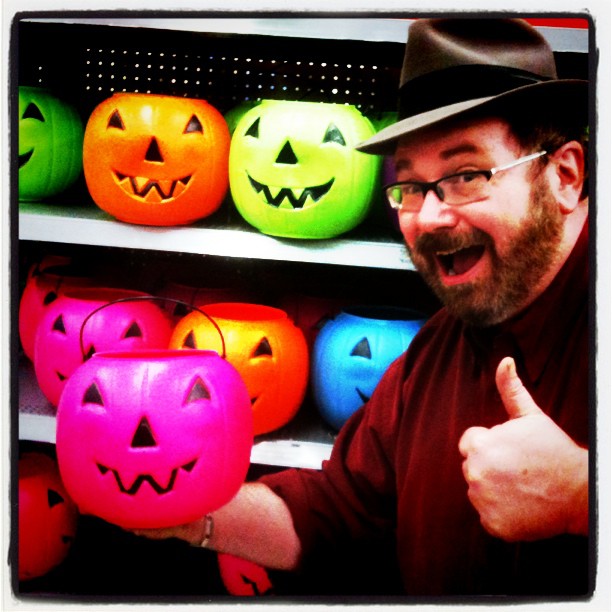 a man in front of shelves full of fake pumpkins