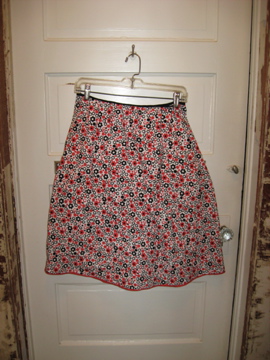 a red and white skirt hanging in a doorway