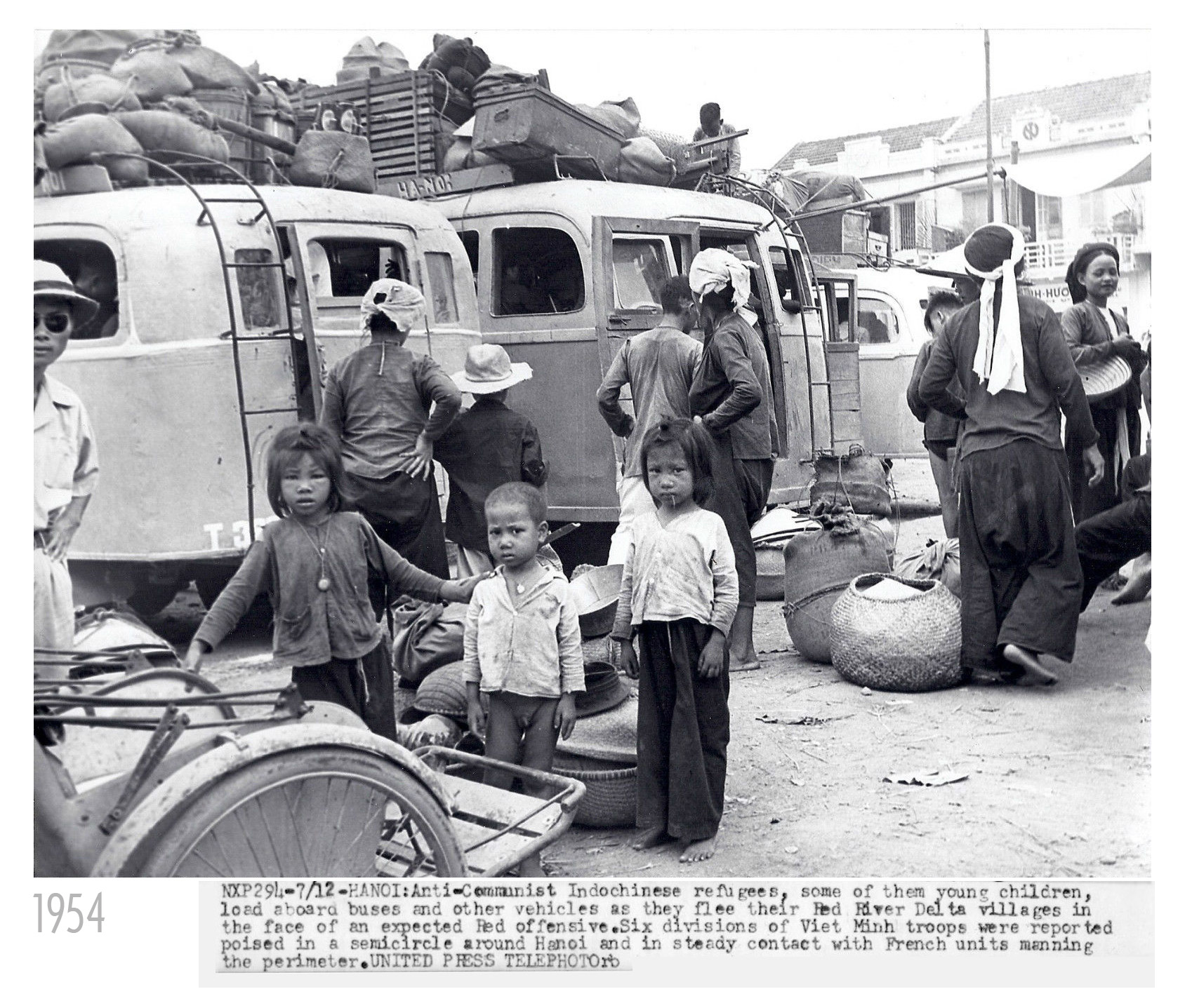 an old po shows a family gathering around cars