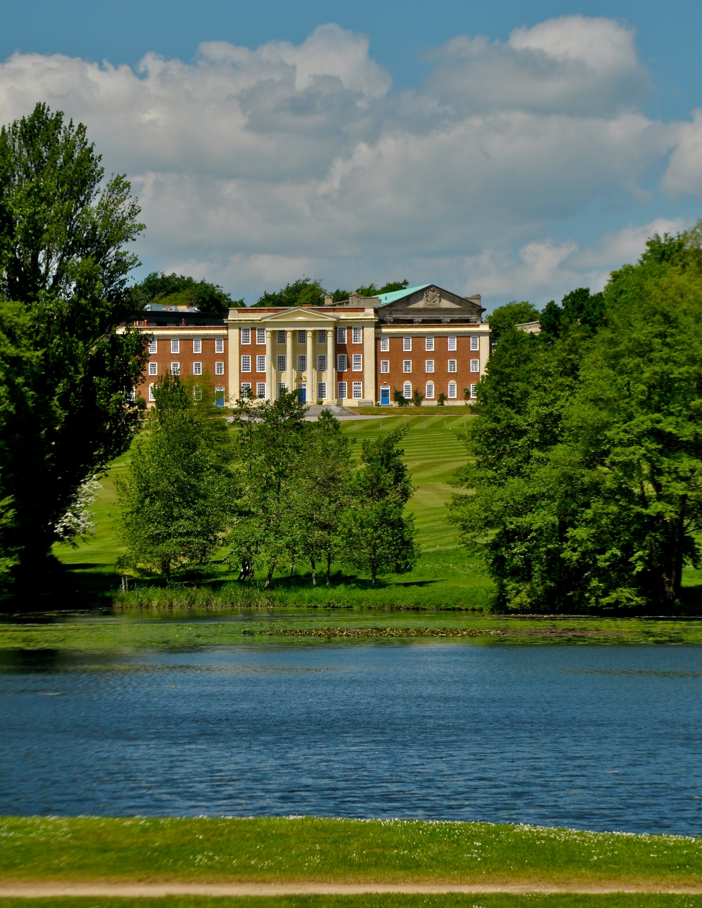 a large mansion sitting in the background next to a lake