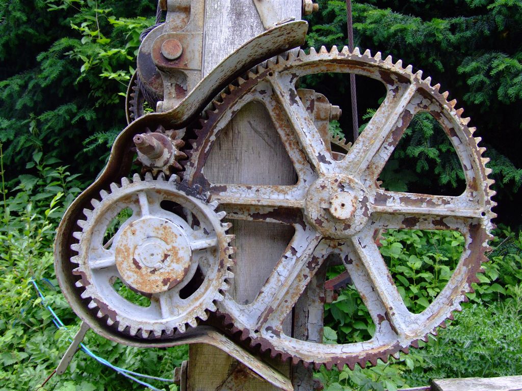 rusty gears from an old wooden object in a garden