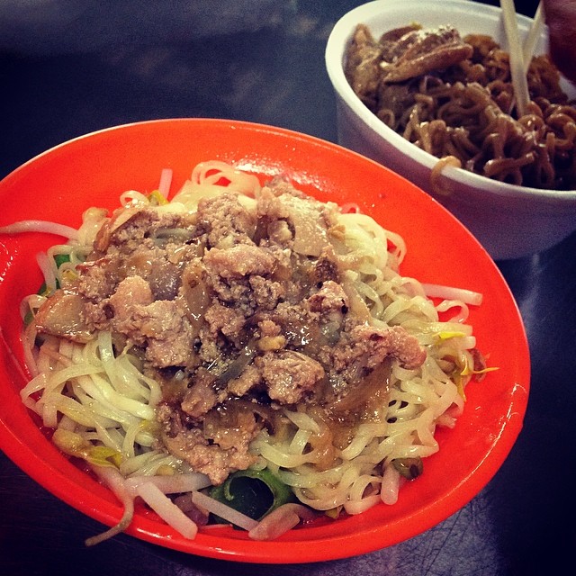 a bowl filled with noodles, meat and vegetables