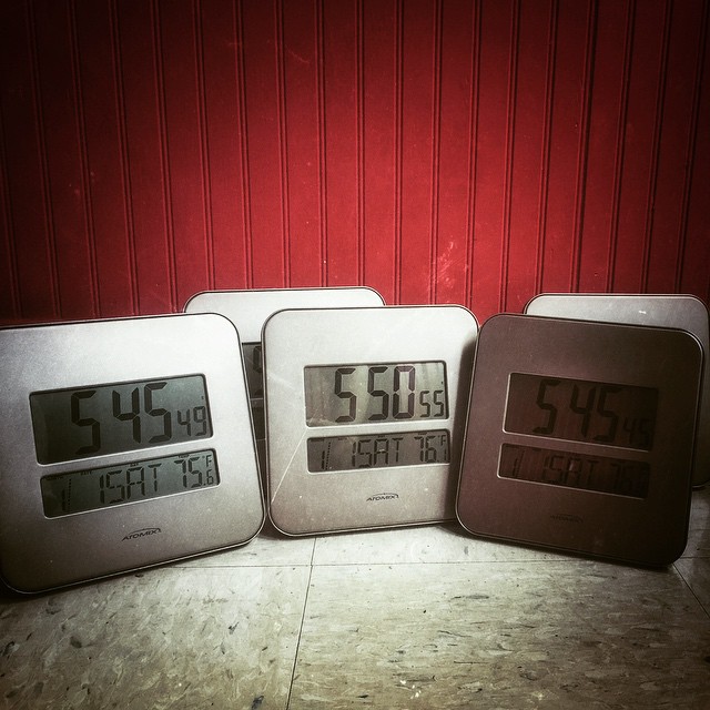 three clocks that have the same time sitting on the floor