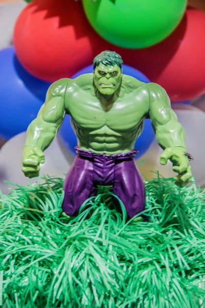 a close up of a small statue of hulk with balloons in the background