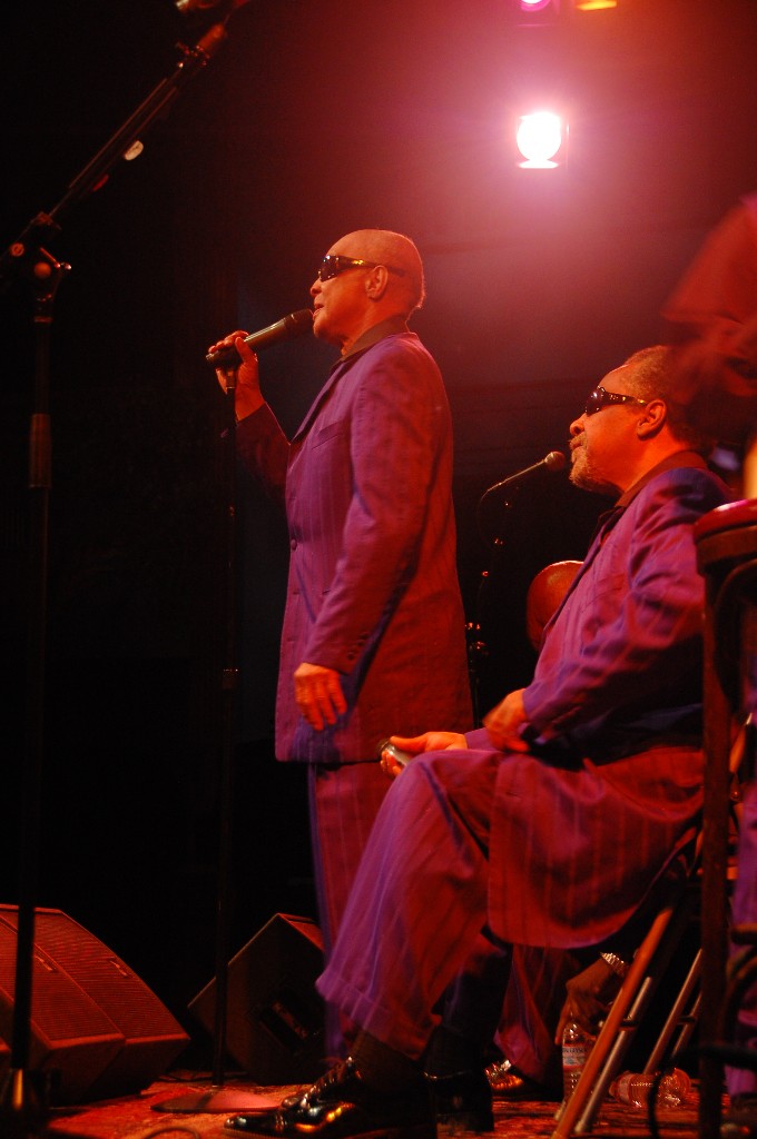 two people in purple suit singing into microphones