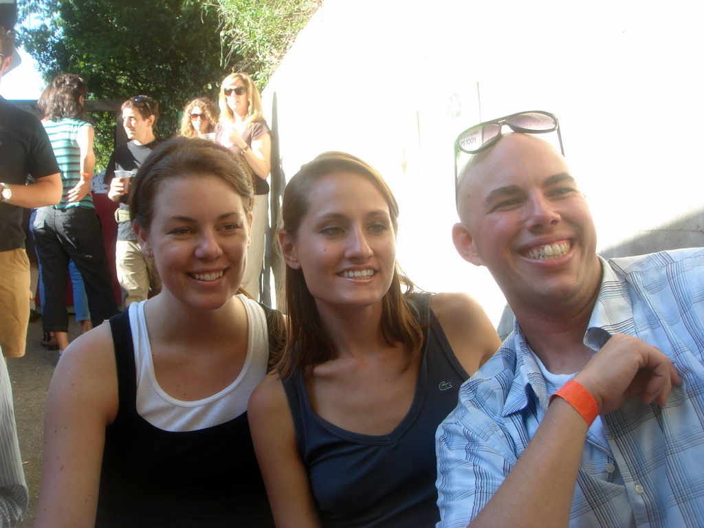 three people sitting close together smiling for the camera