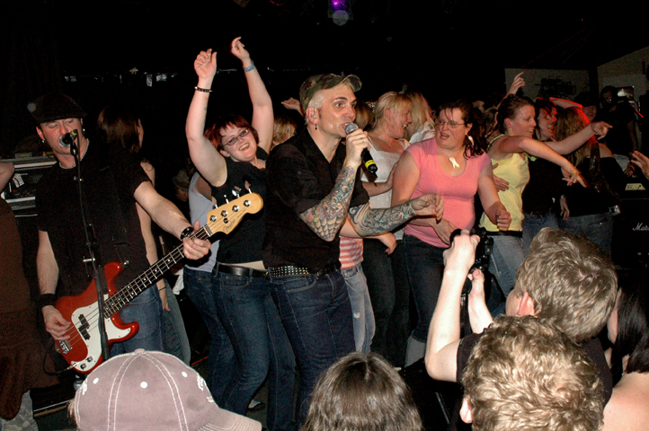 group of people in the audience cheering as the band plays