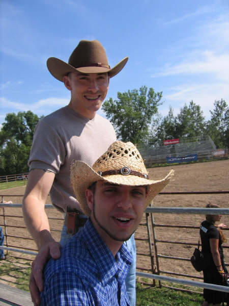 two men in cowboy hats on the shoulders of each other