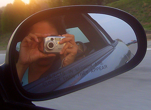 woman taking po of her reflection in her mirror