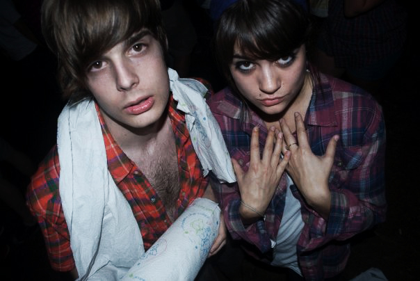 two young adults pose for the camera and one of them holding his hand