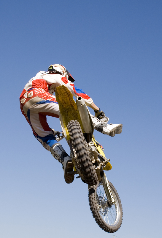 a man flying through the air while riding a dirt bike