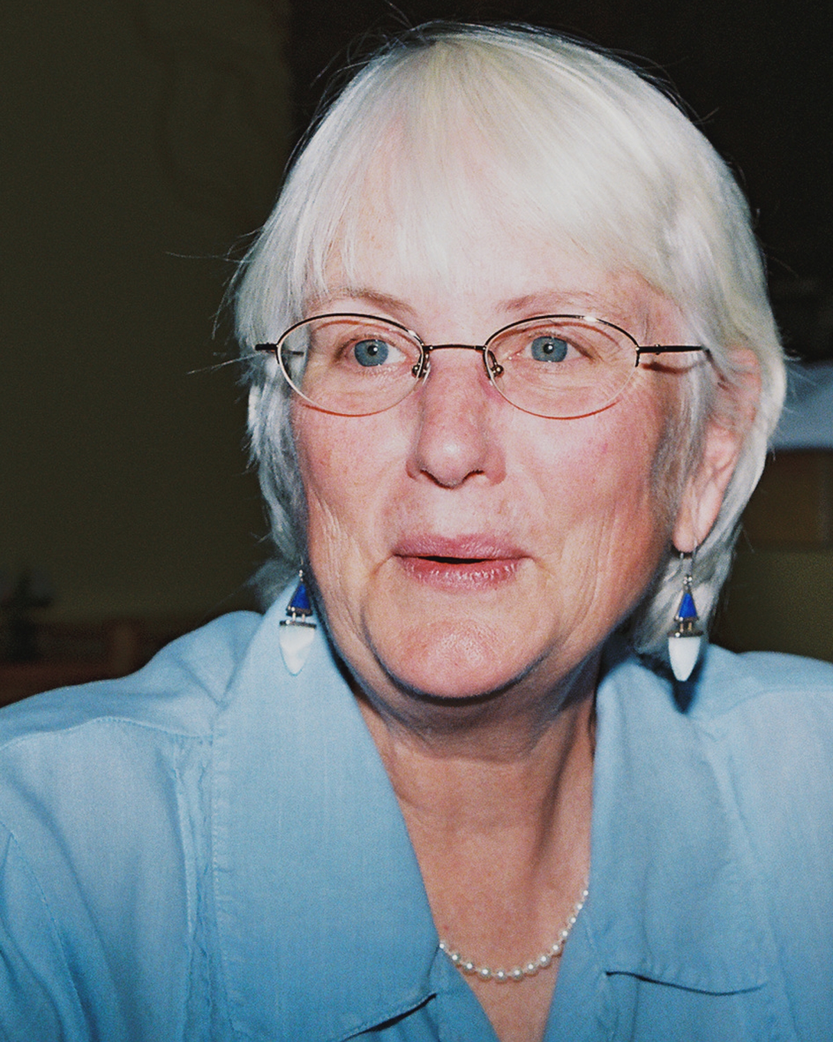 an old woman wearing glasses and a blue shirt