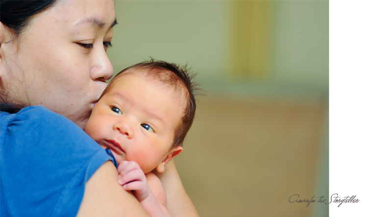 a baby being held in his mom's arms with a surprised look