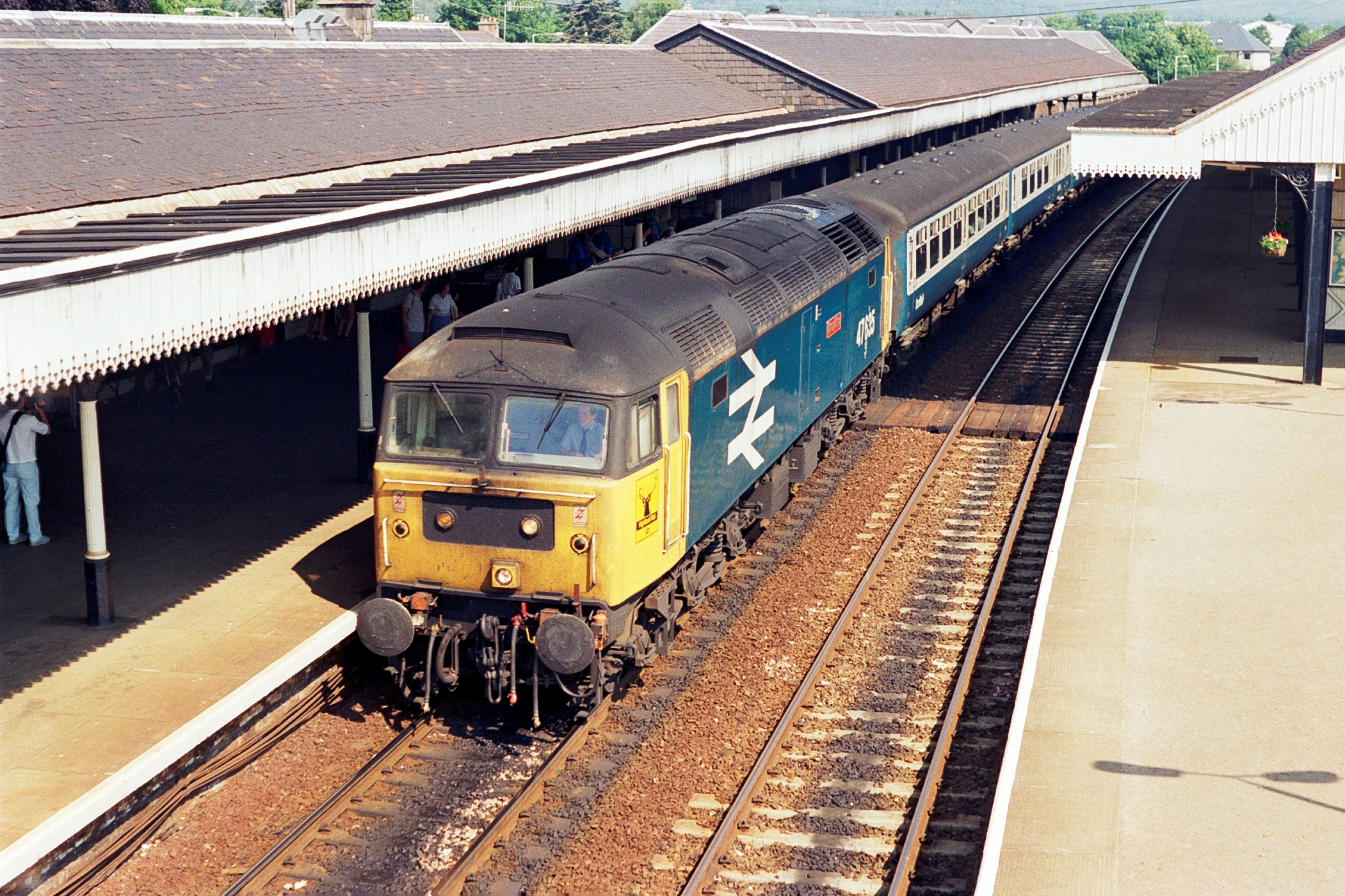 a train traveling under a railway station next to a loading platform