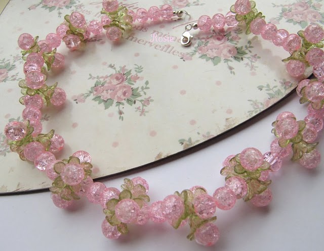 a necklace made with pink flowers on a floral background