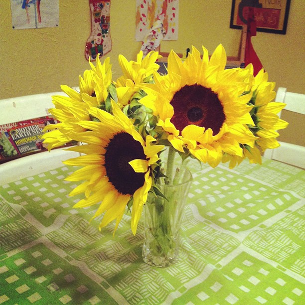 a glass vase filled with sunflowers on a table
