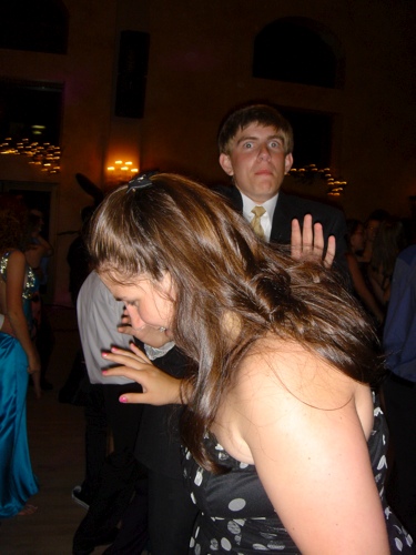 the woman is dancing with a guy wearing a suit and tie