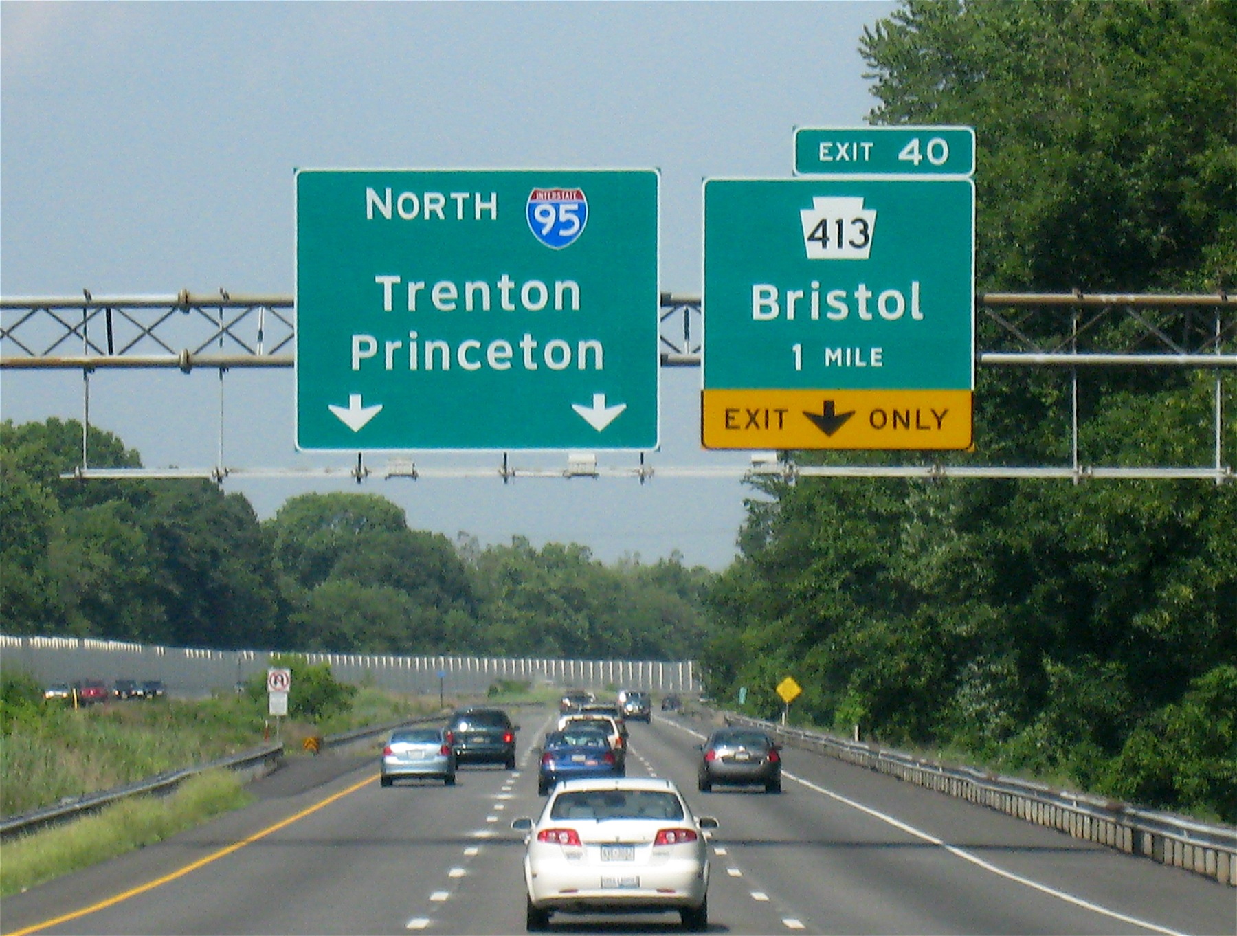 several cars traveling down the highway near trees